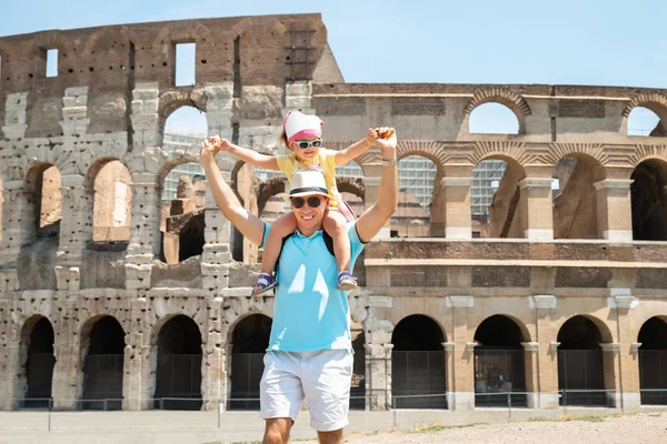 Young Tourist Family Standing In Front Of Colosseum In Rome, Italy