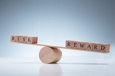 Yansıtıcı Arka Planda Risk ve Ödül Arasındaki Dengesizliği Gösteren Ahşap Bir Tahterevalli'nin Yakın Çekim