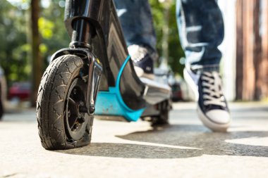 Onun E-Scooter üzerinde düz lastik ile Adam