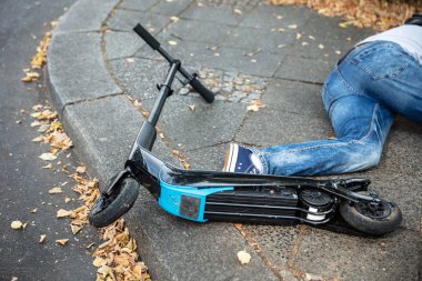 Elektrikli Scooter ile Kaza Sonrası Beton Sokakta Yatan Bilinçsiz Adam