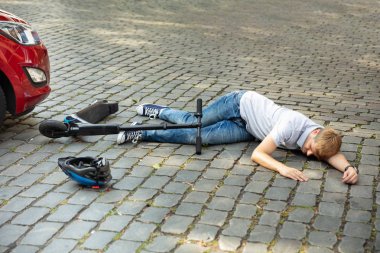 Elektrikli scooter kazası sonrası araba istilasına uğrayan adam.