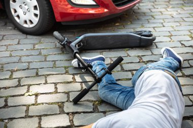 Elektrikli scooter kazası sonrası araba istilasına uğrayan adam.