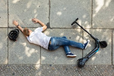 Elektrikli Scooter ile Kaza Sonrası Beton Sokakta Yatan Bilinçsiz Adam