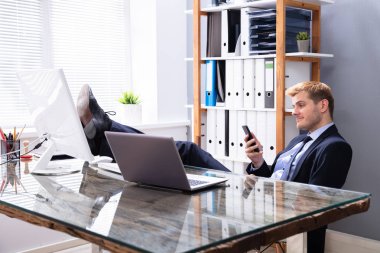 Tembel adam çalışmak yerine iş yerinde telefon kullanıyor.