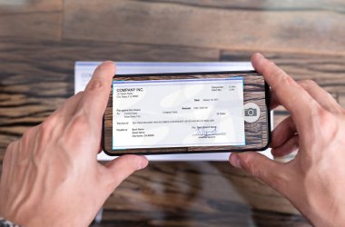 Banka hesabına uzaktan para yatırmak için çek çeken bir adam.