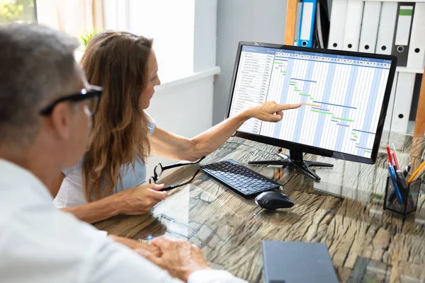 オフィスのコンピュータ上でガントチャートとカレンダーを分析する成熟したビジネスマン — ストック写真