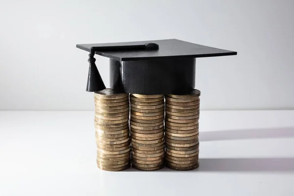 Gorra Graduación Negra Con Borla Cerca Apilados Monedas Aisladas Sobre — Foto de Stock