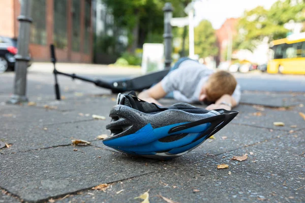 无意识的人躺在混凝土街道后事故与电动滑板车 — 图库照片