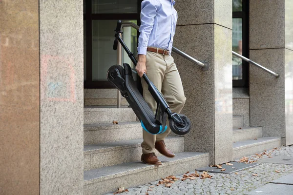 Man Draagt Scooter Van Het Werk Lopen Uit Kantoorgebouw — Stockfoto