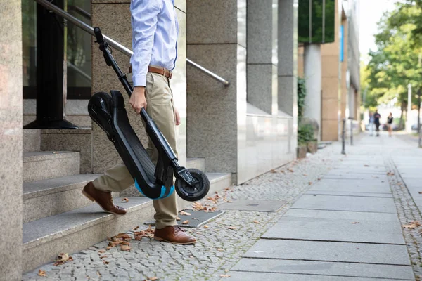 Mężczyzna Niosący Scooter Pracy Wychodzący Budynku Biurowego — Zdjęcie stockowe