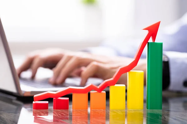 Growth Chart Near Man Working On Laptop