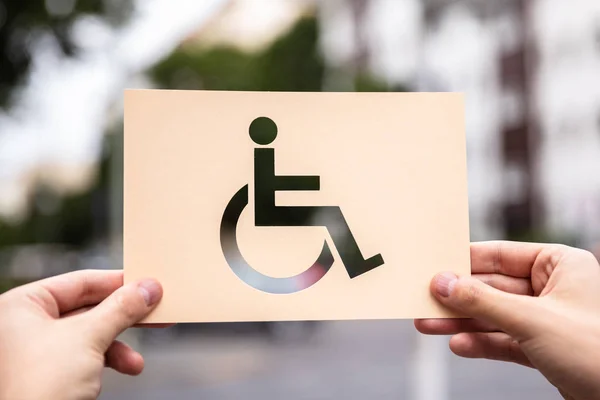 Mani Possesso Carta Con Ritaglio Segno Disabili All Aperto — Foto Stock