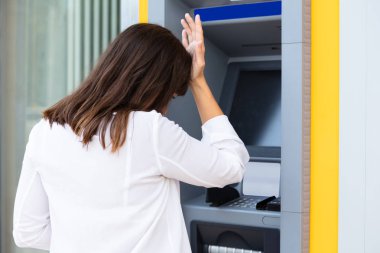 Hesapları kontrol ettikten sonra ATM 'ye bakan Hayal kırıklığına uğramış genç kadının yakın çekimi