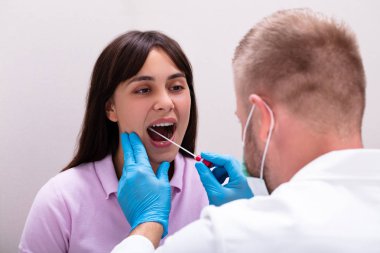 Erkek bir doktorun DNA testi için vücut sıvısı örneği alırken görüntüsü.