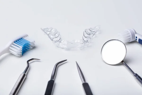 白い背景に歯科用器具とクリアアライナー — ストック写真