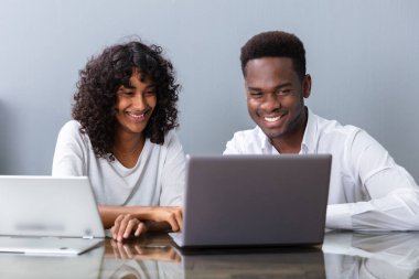 Ofiste dizüstü bilgisayarda çalışan iki iş adamı