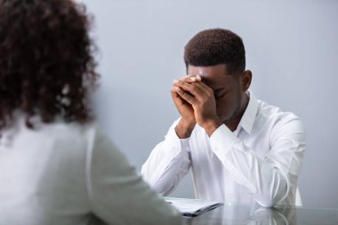 Ofisteki görüşmede kafasını tutan stresli genç iş adamı