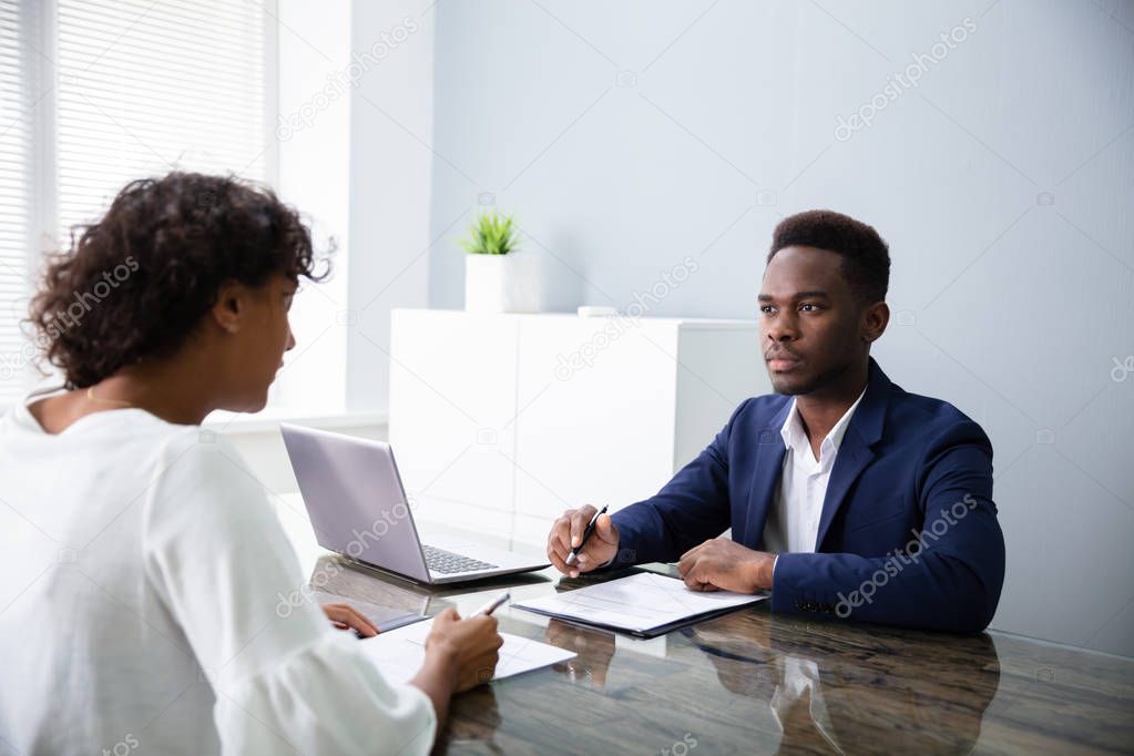 Young Businesspeople Sitting At Interview In Office