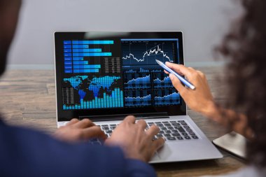 Dizüstü bilgisayarda Mali Grafik Analizi Yapan İki İşadamı
