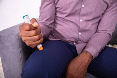 Man Injecting Epinephrine Using Auto-injector Syringe As An Emergency Treatment For Allergic Reaction  clipart