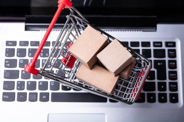Dizüstü bilgisayardaki alışveriş arabasındaki karton kutuların yükseltilmiş görüntüsü