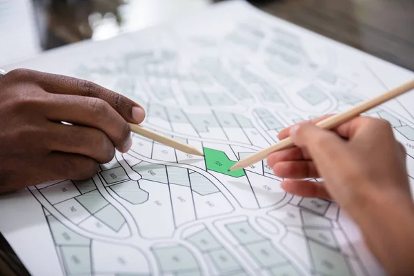 Mãos Segurando Lápis Sobre Cadastre Mapa Fotos Stock — Fotografia de Stock