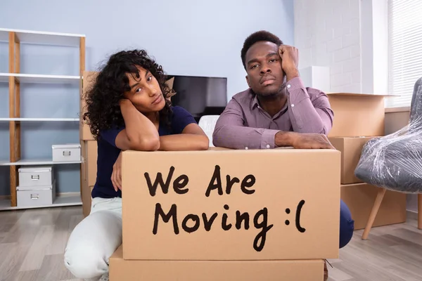 Stressed Couple Sitting Near Boxes In New Home