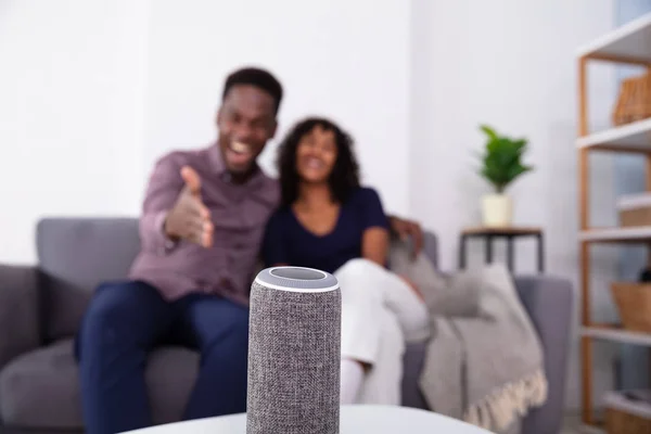 Close-up Of Wireless Speaker In Front Of African Couple