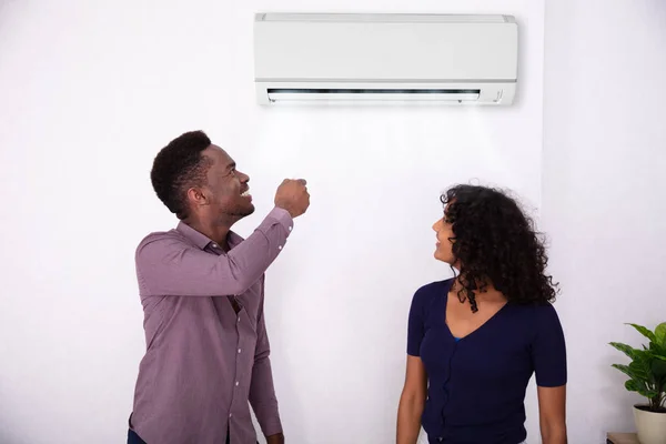 Couple Adjusting Temperature Air Conditioner Home — Stock Photo, Image