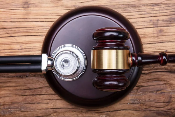 Vista Ângulo Alto Gavel Com Estetoscópio Arranjado Tabela Madeira — Fotografia de Stock