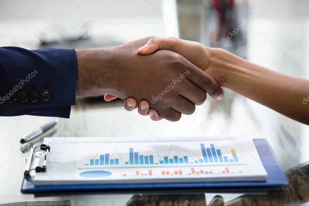 Business People Shaking Hands Over Profits Chart 