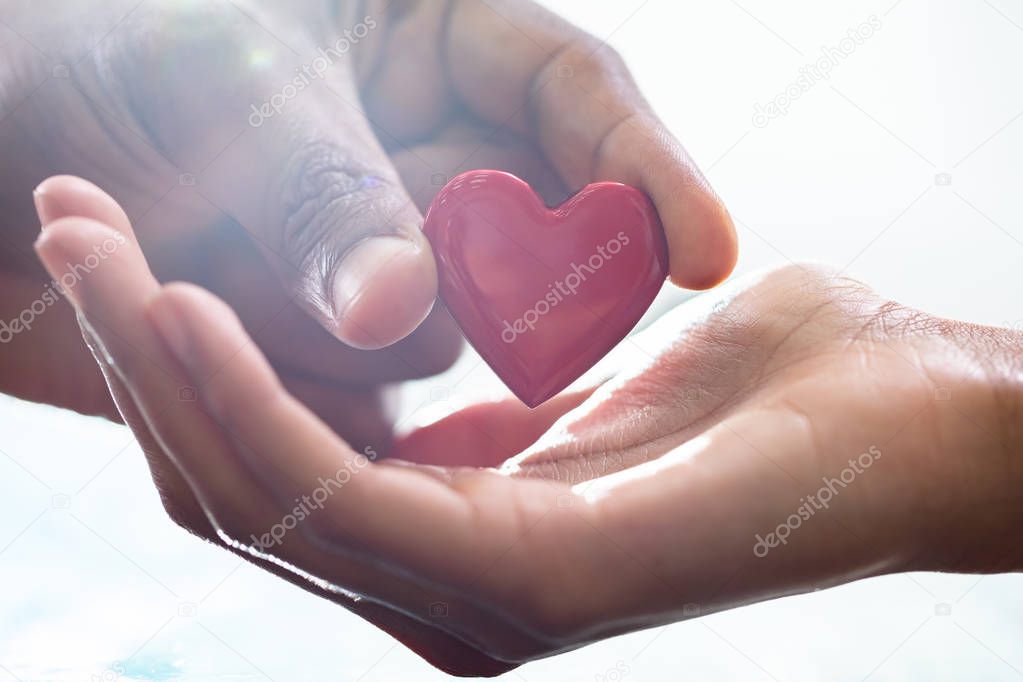 Male Hand Giving Heart Shape To Female