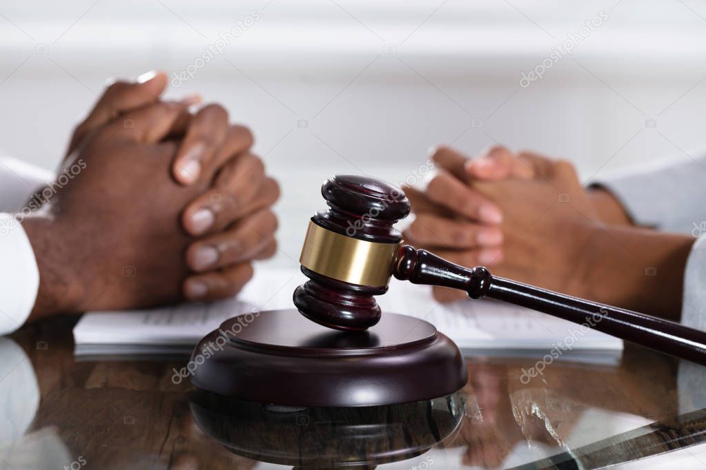 Divorce Concept With Gavel And Wife And Husband Hands On Desk