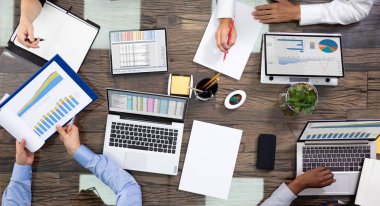 Bir grup şirket yöneticisinin toplantı odasında verileri tartışırken yüksek açılı görüntüsü
