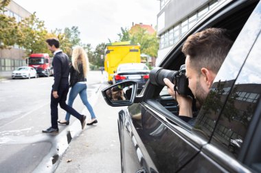Private Detective Taking Photos Of Man And Woman On Street clipart