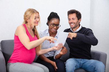 Surrogate Mother Showing Ultrasound Baby Images To Young Couple clipart