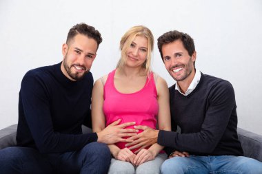 Portrait Of A Smiling Men Touching The Belly Of Pregnant Surrogate Woman clipart