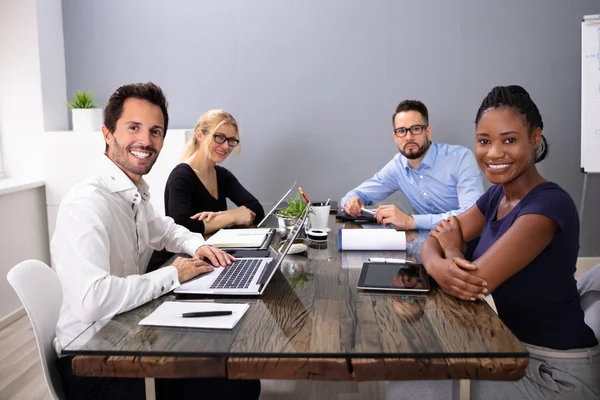 Grupa Uśmiechniętych Biznesmenów Patrzących Kamerę Siedzącą Laptopem Biurze — Zdjęcie stockowe