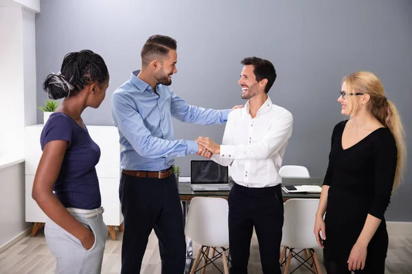 Frauen Schauen Glücklichen Jungen Geschäftsmännern Beim Händeschütteln Besprechungsraum — Stockfoto