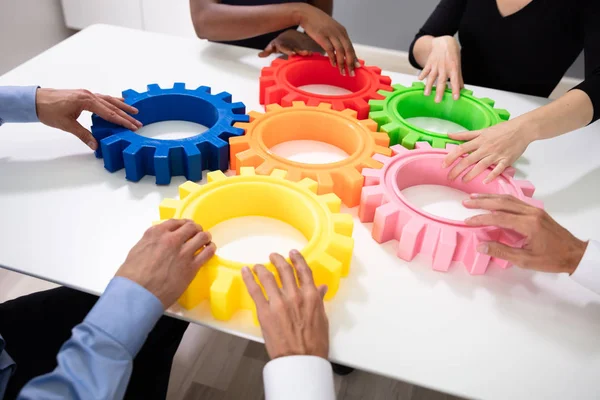 Group Businesspeople Arranging Colorful Cog Wheels Together White Table Office — Stock Photo, Image