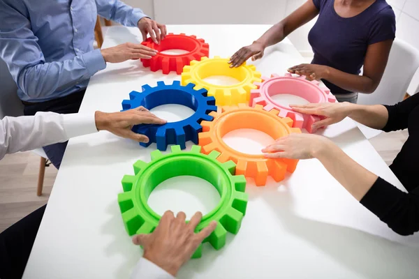 Group Businesspeople Arranging Colorful Cog Wheels Together White Table Office — Stock Photo, Image