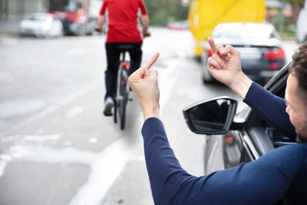 自転車で女性に中指を示す怒っているドライバ — ストック写真