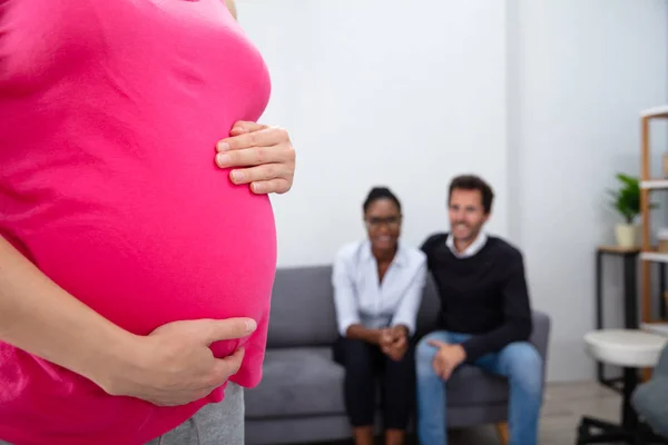 Schwangere Berührt Frau Bauch Die Vor Lächelndem Jungen Paar Sitzt — Stockfoto