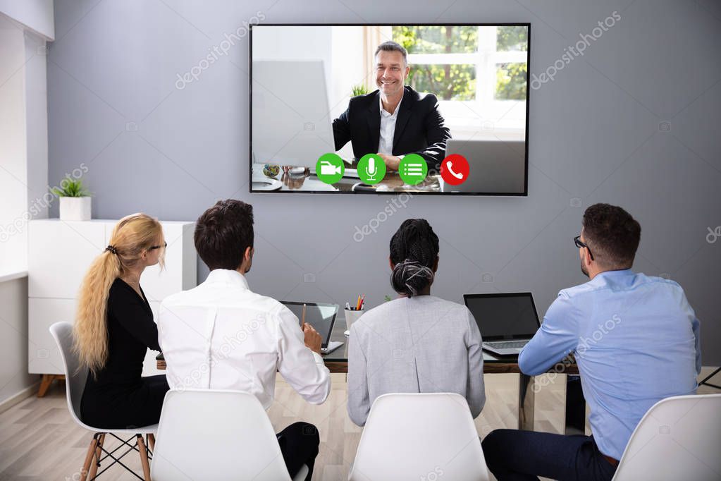 Businesspeople Sitting In A Conference Room Looking At Computer Screen