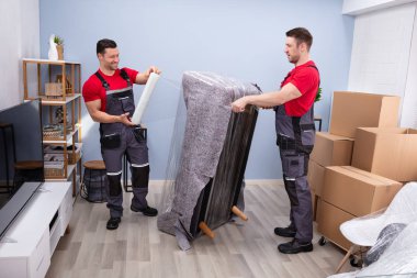 İki Genç Erkek Taşıyıcı Oturma Odası 'na Plastik Paket Yapıyor