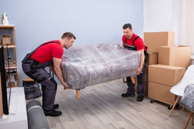İki Mutlu Genç Erkek Taşıyıcı 'nın Portresi Yeni Ev' de Paketli Kanepe Taşıyor