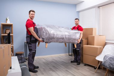 İki Mutlu Genç Erkek Taşıyıcı 'nın Portresi Yeni Ev' de Paketli Kanepe Taşıyor