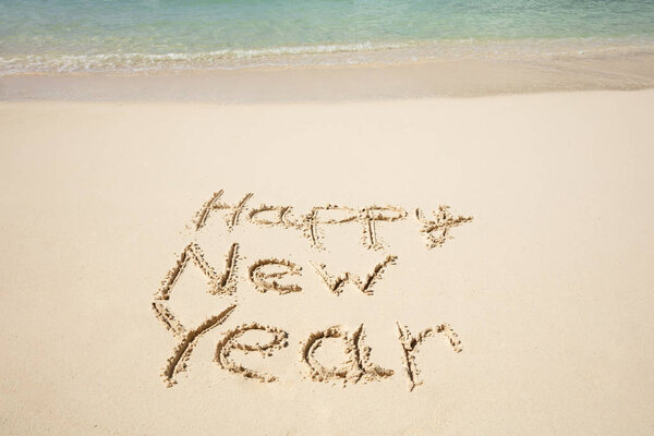 Happy New Year Text Written On Sand Near The Sea At Beach