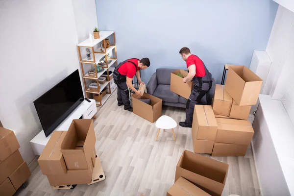 Two Young Movers Uniform Picking Putting Products Cardboard Boxes — Stock Photo, Image