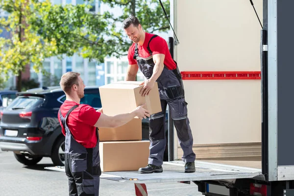 Dois Jovens Homens Caixas Papelão Transporte Uniforme Caminhão — Fotografia de Stock